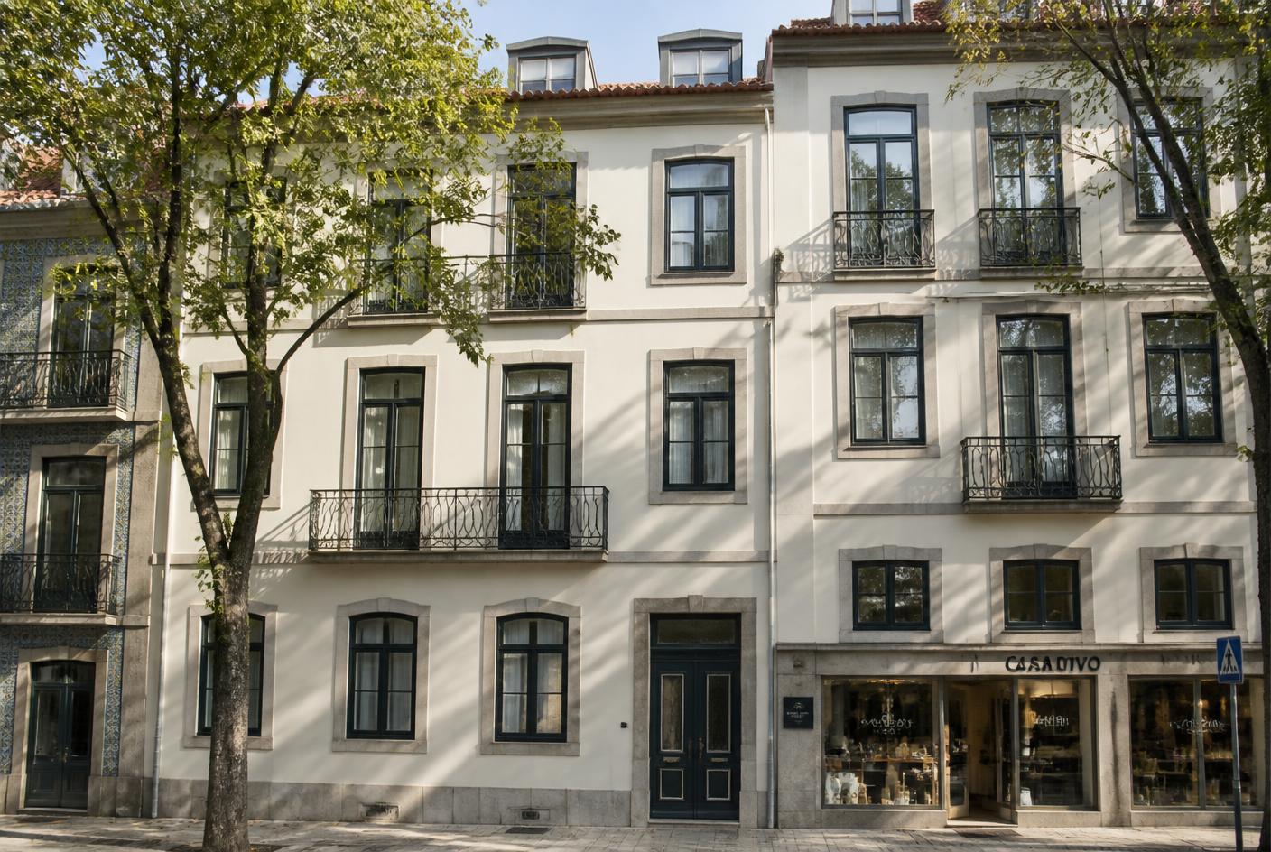 Fachada de edifício residencial reabilitado numa avenida arborizada do Porto